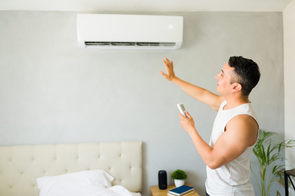 Man turning on inside unit of ductless ac system
