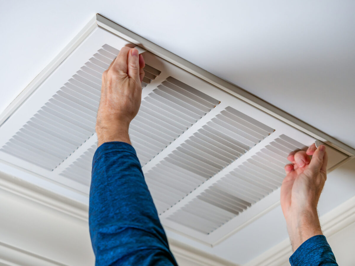 AC technician opening vent in home